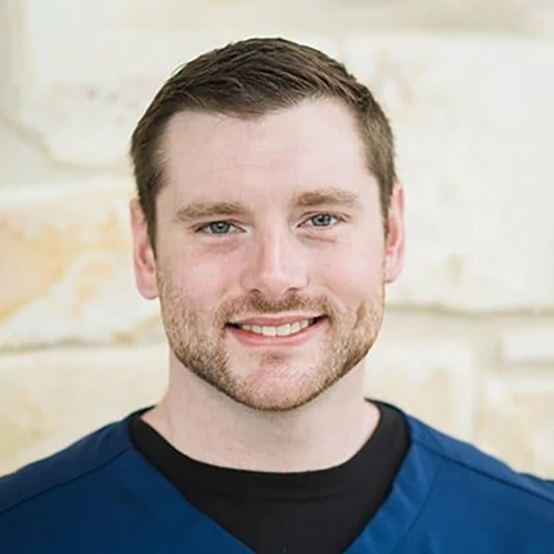 Carlson Thwing smiling in front of a stone wall.